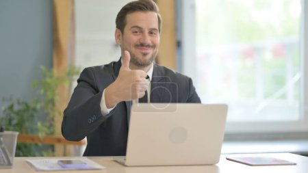 Photo for Thumbs Up by Businessman on Laptop - Royalty Free Image