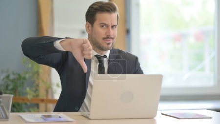 Photo for Thumbs Down by Businessman Working on Laptop - Royalty Free Image