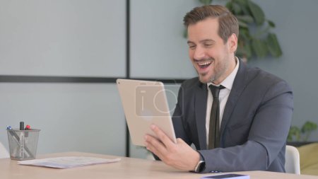 Téléchargez les photos : Homme d'affaires célébrant le succès sur tablette PC - en image libre de droit