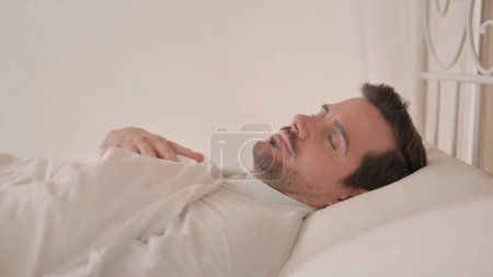 Photo for Side View of Young Man Sleeping in Bed - Royalty Free Image