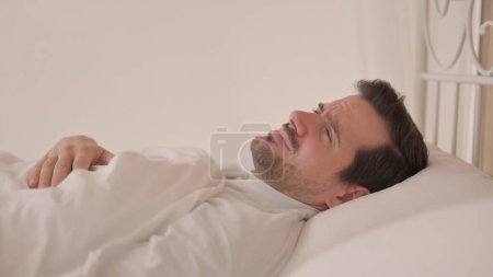 Photo for Side View of Young Man Feeling Sick in Bed - Royalty Free Image