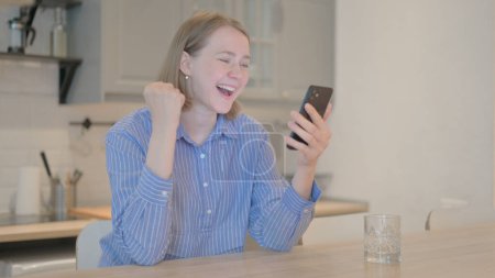 Photo for Young Woman Celebrating Online Win on Phone - Royalty Free Image