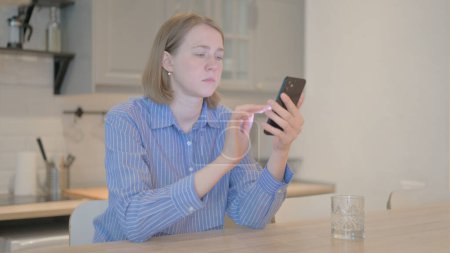 Photo for Young Woman Using Smartphone at Work - Royalty Free Image