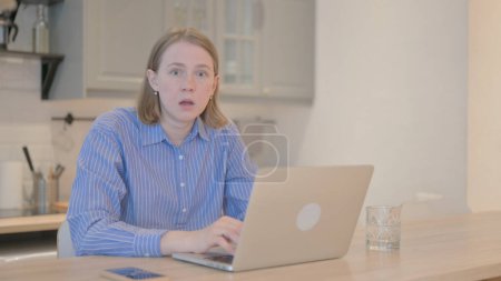Photo for Shocked Young Woman Looking at Camera while Working on Laptop - Royalty Free Image