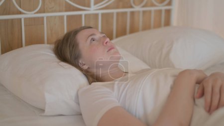 Foto de Mujer joven despertando y dejando la cama - Imagen libre de derechos