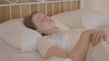 Photo for Tired Young Woman Sleeping in Bed at Home - Royalty Free Image