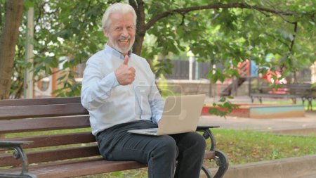 Foto de Pulgares hacia arriba por el anciano mayor en el ordenador portátil al aire libre - Imagen libre de derechos