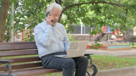 Foto de Anciano mayor hablando por teléfono y utilizando el ordenador portátil al aire libre - Imagen libre de derechos