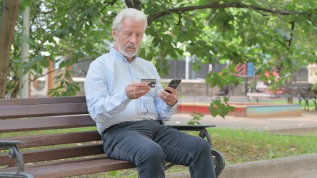 Foto de Anciano mayor haciendo compras en línea en el teléfono mientras está sentado al aire libre - Imagen libre de derechos