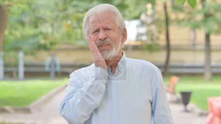 Téléchargez les photos : Portrait extérieur de vieil homme âgé avec mal de dents - en image libre de droit