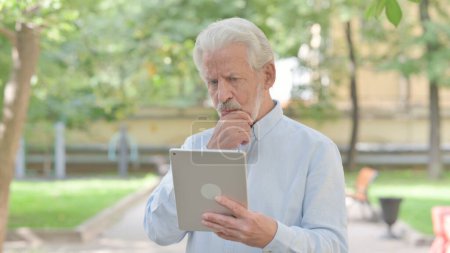 Foto de Anciano mayor molesto por la pérdida en la tableta al aire libre - Imagen libre de derechos