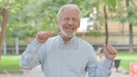 Téléchargez les photos : Vieil homme âgé excité dansant en plein air - en image libre de droit