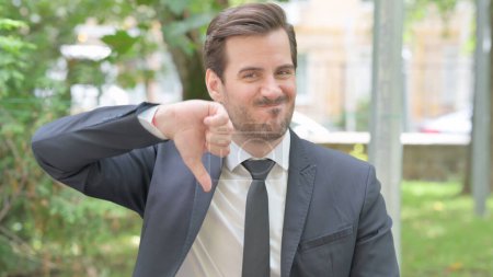 Photo for Outdoor Portrait of Young Businessman Doing Thumbs Down - Royalty Free Image