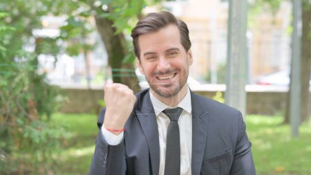 Téléchargez les photos : Portrait en plein air d'un jeune homme d'affaires excité célébrant son succès - en image libre de droit
