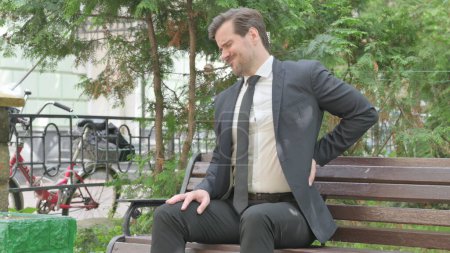 Photo for Middle Aged Businessman Sitting Outdoor with Back Pain - Royalty Free Image