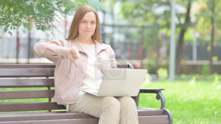 Thumbs Down by Senior Old Woman on Laptop Outdoor