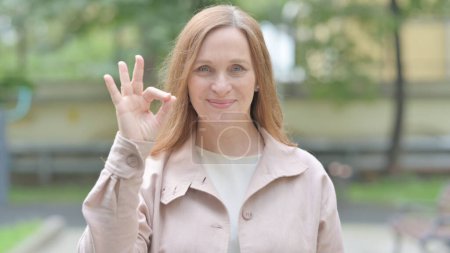 Outdoor Portrait of Old Woman Doing Ok Sign