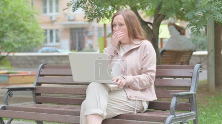 Sick Modern Old Woman Coughing and Using Laptop Outdoor