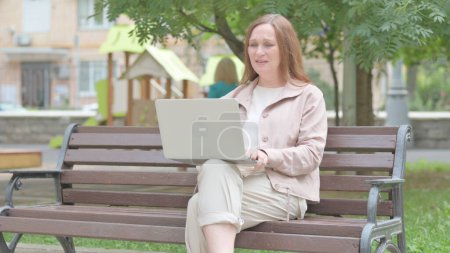 Photo for Modern Old Woman Facing Online Loss on Laptop Outdoor - Royalty Free Image