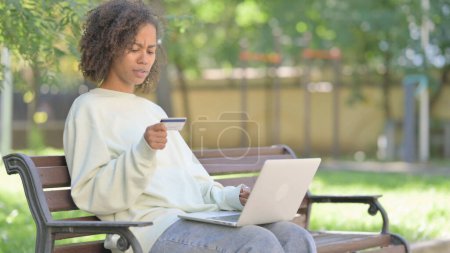 Téléchargez les photos : Jeune femme africaine bouleversé par l'échec de paiement en ligne sur ordinateur portable en plein air - en image libre de droit