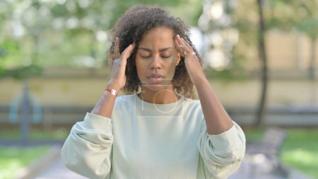 Téléchargez les photos : Portrait extérieur de jeune femme africaine fatiguée avec Migraine - en image libre de droit