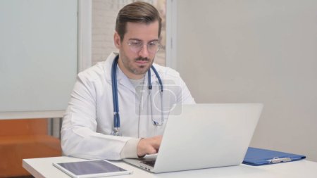 Photo for Middle Aged Doctor Working on Laptop - Royalty Free Image