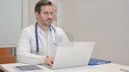 Foto de Negando Doctor Edad Media Restringir mientras se utiliza el ordenador portátil - Imagen libre de derechos