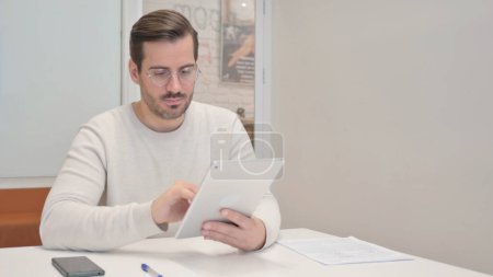 Téléchargez les photos : Homme du Moyen Âge en utilisant une tablette numérique dans le bureau - en image libre de droit