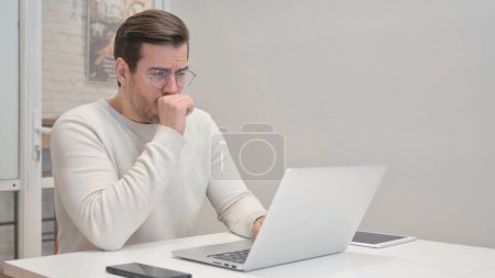 Photo for Coughing Middle Aged Man Using Laptop in Office - Royalty Free Image
