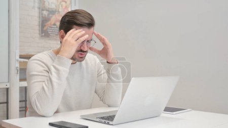 Foto de Hombre de mediana edad sorprendido por la pérdida en el ordenador portátil en la oficina - Imagen libre de derechos