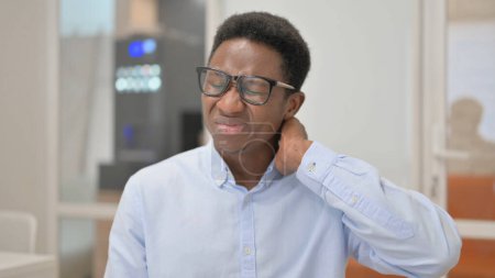 Foto de Retrato del empresario africano con dolor de cuello en el cargo - Imagen libre de derechos