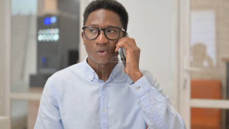 Téléchargez les photos : Portrait d'un homme d'affaires africain parlant au téléphone - en image libre de droit