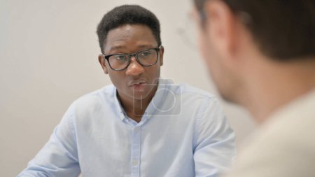 Téléchargez les photos : Un homme d'affaires africain s'entretient avec un travailleur au bureau - en image libre de droit