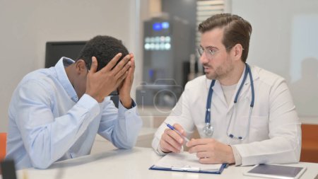Photo for Man with Headache Consulting a Male Doctor - Royalty Free Image
