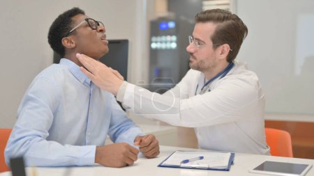 Doctor Checking Tonsils of Male African Patient in Clinic
