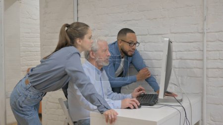 Téléchargez les photos : Mixte personnes de race travaillant sur l'ordinateur au bureau - en image libre de droit