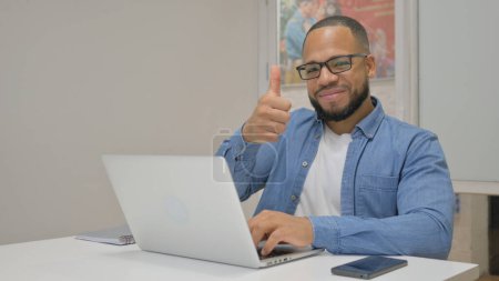 Photo for Thumbs Up by African Businessman Using Laptop - Royalty Free Image