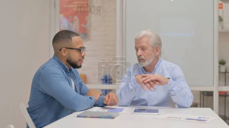 Foto de Viejo Empresario Hablando con el Hombre de Raza Mixta - Imagen libre de derechos