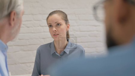 Photo for Angry Young Woman Talking with Colleagues - Royalty Free Image