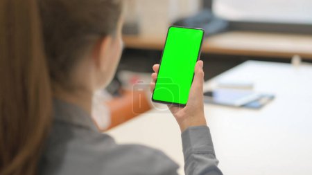 Téléchargez les photos : Jeune femme utilisant le téléphone avec écran vert - en image libre de droit