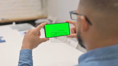 Téléchargez les photos : Homme africain tenant téléphone horizontal avec écran vert - en image libre de droit