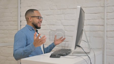 Foto de Hombre de raza mixta hablando durante el chat de vídeo en la computadora - Imagen libre de derechos