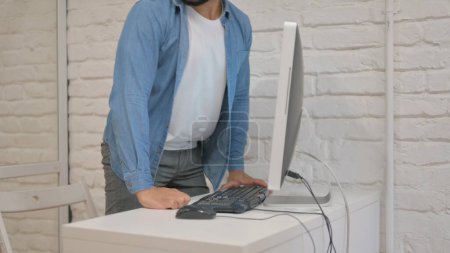 Téléchargez les photos : Homme de race mixte quittant le bureau après avoir travaillé sur ordinateur - en image libre de droit