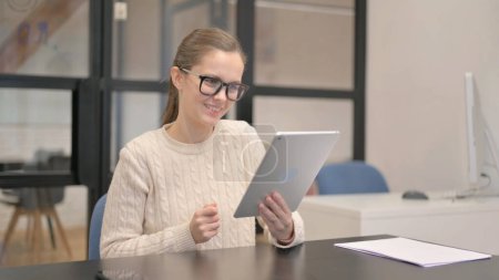 Foto de Mujer joven haciendo Video Chat en Tablet en la Oficina - Imagen libre de derechos
