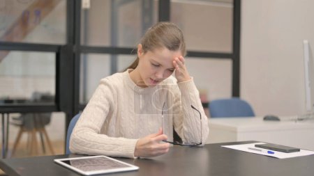 Téléchargez les photos : Young Woman having Headache while Sitting in Office - en image libre de droit