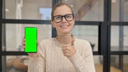 Téléchargez les photos : Femme positive tenant l "écran de téléphone intelligent vert Chroma Key - en image libre de droit