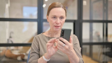 Photo for Portrait of Senior Businesswoman Reacting to Loss on Phone - Royalty Free Image