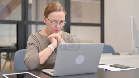 Photo for Old Businesswoman Shocked by Loss on Laptop in Office - Royalty Free Image