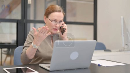 Téléchargez les photos : Angry Old Businesswoman Parler au téléphone - en image libre de droit