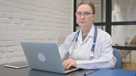 Gesture of Denial by Old Lady Doctor Using Laptop
